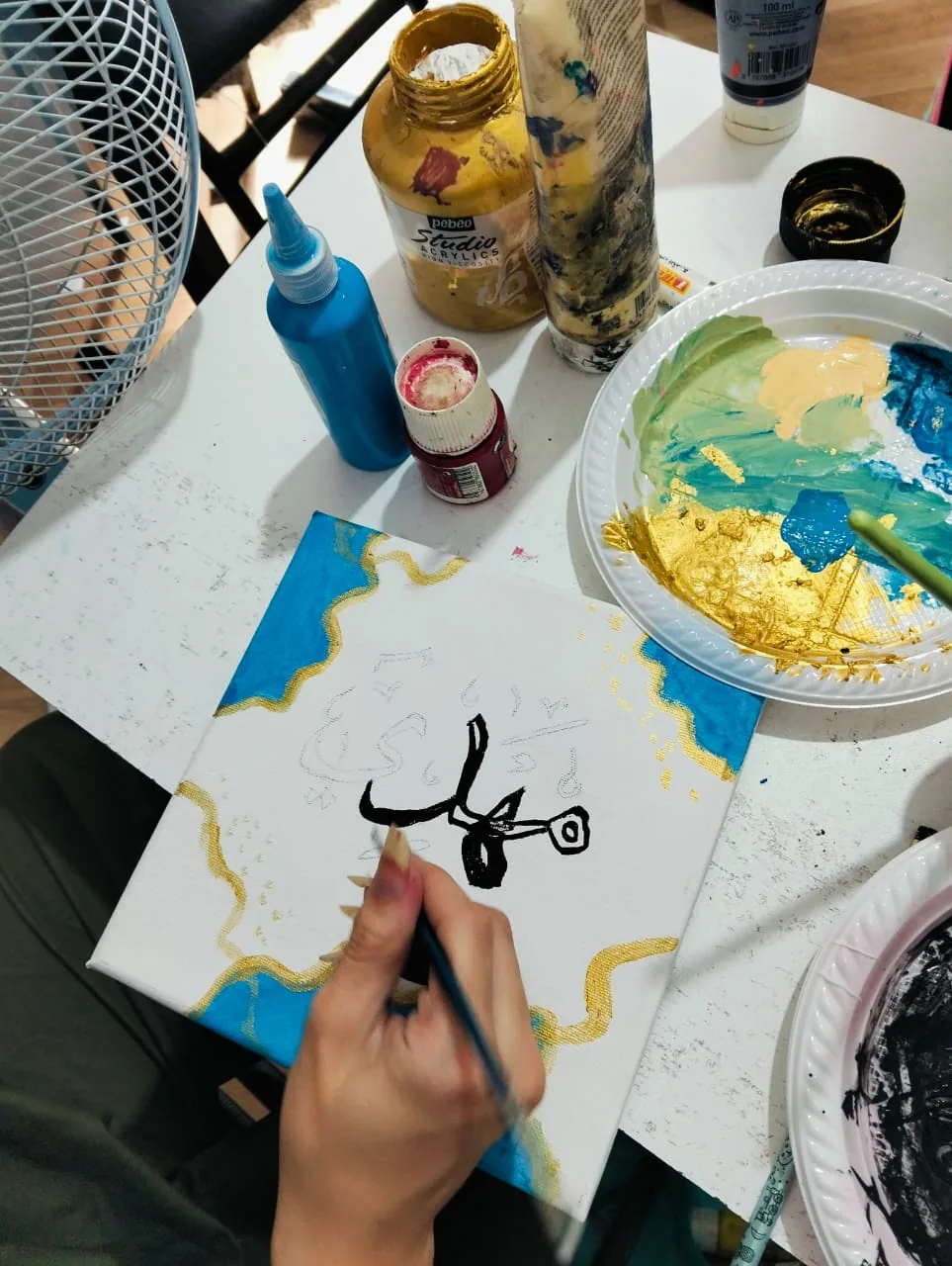 Enfant réalisant une peinture calligraphique pendant un atelier créatif PLC