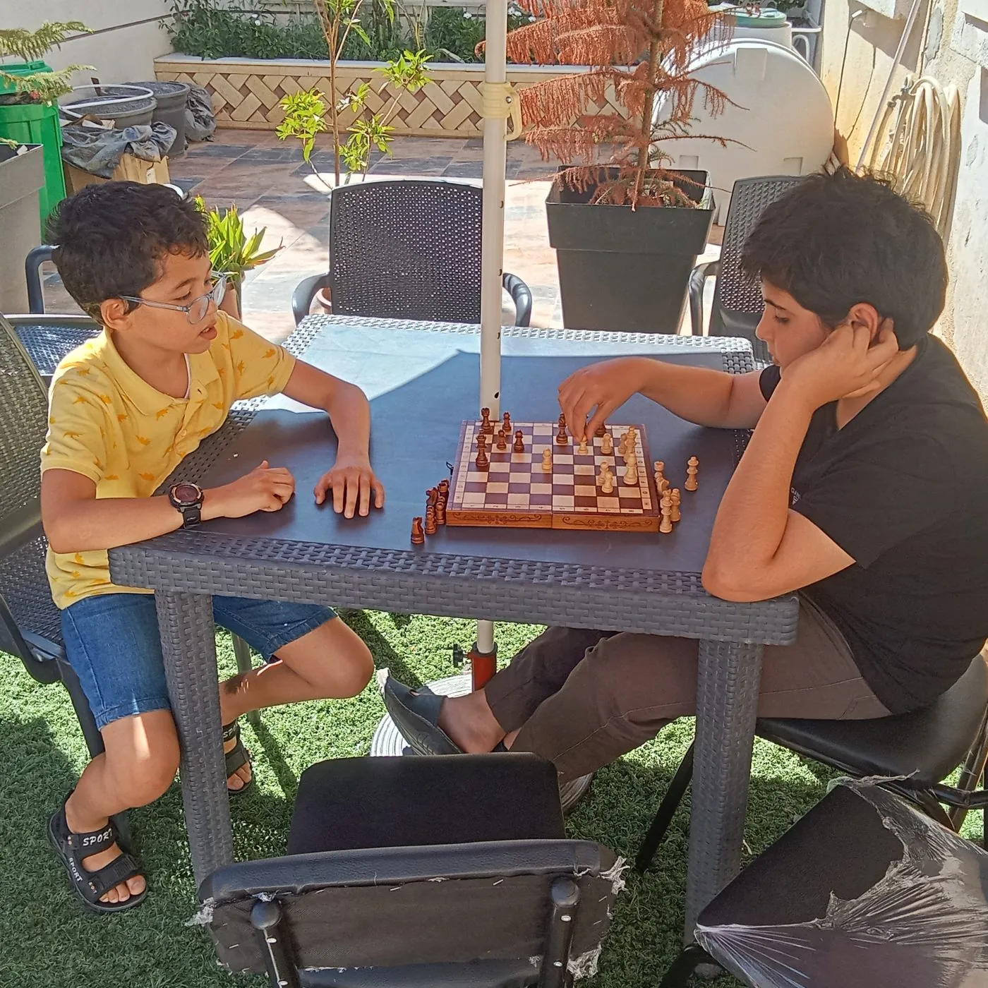 Deux enfants jouant aux échecs en extérieur